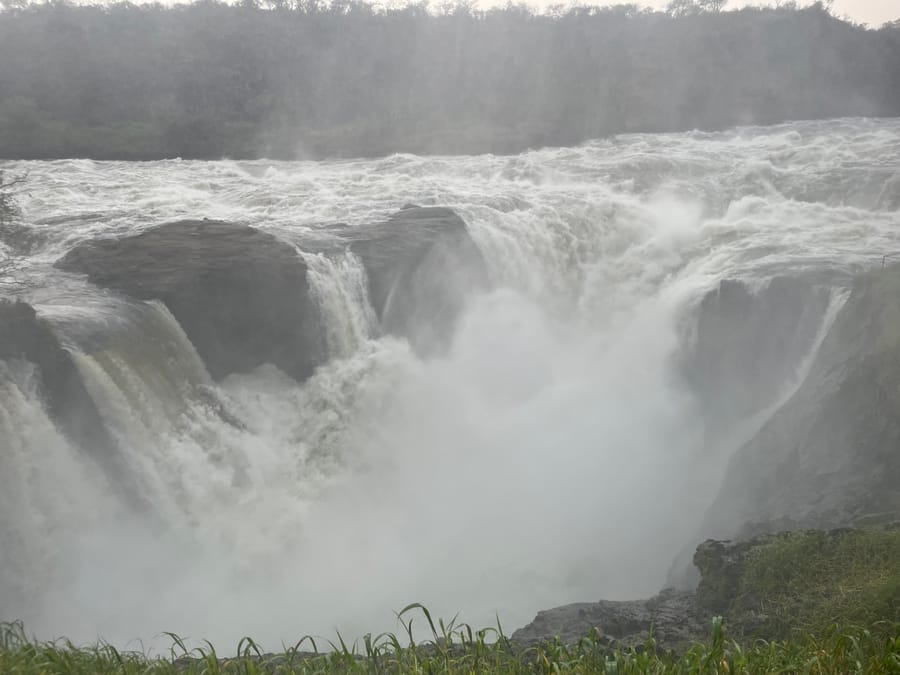 The falls pouring over dark ledges into the mist