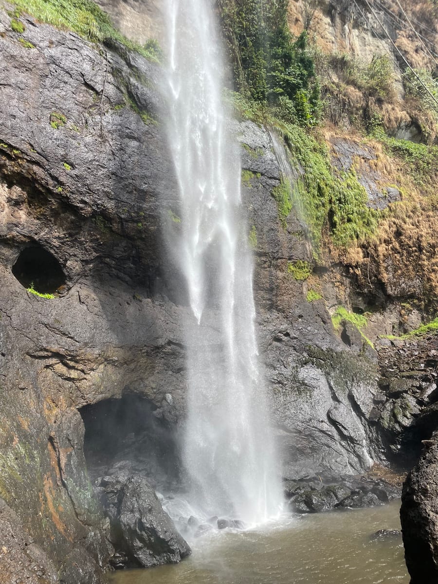 The column falling past cave hollows into the plunge pool